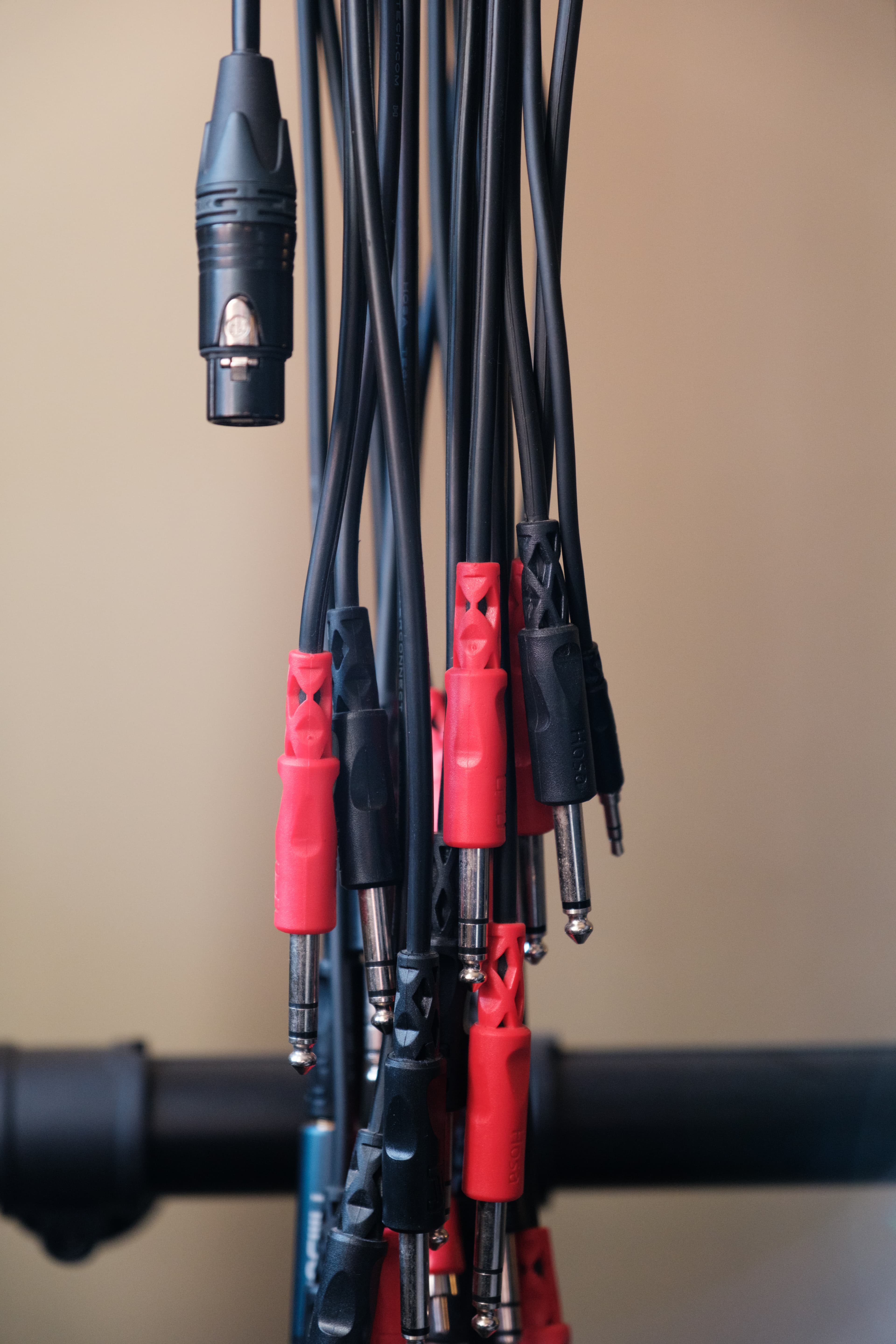 Bundle of XLR and TRS patch cables hanging in a studio